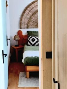 アブリエスにあるAppartement cozy - 4 à 6 personnesのベッドとランプ付きのテーブルがある寝室