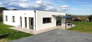 een wit huis met een zwart dak bij Le moulin de maquens in Carcassonne