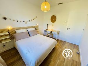 een slaapkamer met een groot wit bed en een bureau bij Le moulin de maquens in Carcassonne