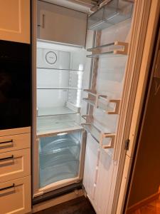 an empty refrigerator with its door open in a kitchen at 3 bedrooms with Tour Eiffel view in Issy-les-Moulineaux +86 photos