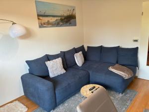 a blue couch in a living room with a table at Wohnung HaHü in Dangast