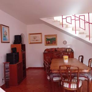 een eetkamer met een houten tafel en een trap bij Villa Armonia in Spigno Saturnia