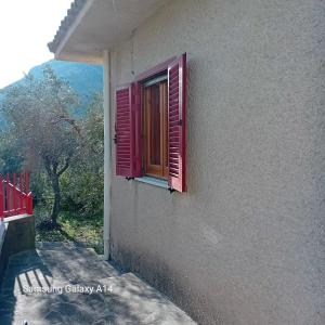 een raam in een gebouw met een rode luik bij Villa Armonia in Spigno Saturnia