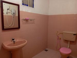 a bathroom with a sink and a toilet and a mirror at Kenashi Green Villa in Weligama