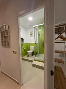 baño con aseo y puerta de cristal en Casa Mencía, en Plasencia