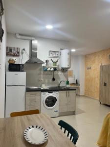 cocina con mesa y lavadora en Casa Mencía, en Plasencia