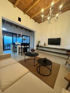 ein Wohnzimmer mit einer Couch, einem Fernseher und einem Tisch in der Unterkunft Farrell Jardin - Casco Historico in San Antonio de Areco + 16 Fotos