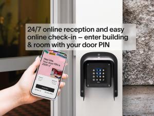 a person holding a cell phone in front of a door at Numa Berlin Potsdamer Platz in Berlin