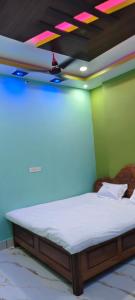 a bed in a room with neon lights on the ceiling at Royal inn in Patna
