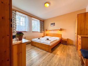 Penzion U Studeného potoka في نوفي هوتو: غرفة نوم بها سرير ومكتب