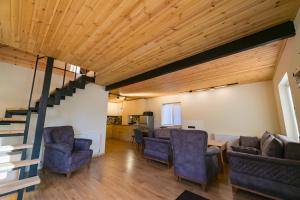 sala de estar con sillas azules y escalera en Gudauri Private Cottage 2, en Gudauri