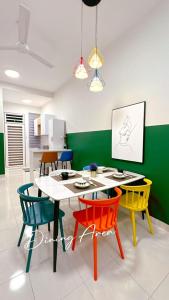 Grand Green Homestay في Sungai Pelik: غرفة طعام مع طاولة وأربعة كراسي