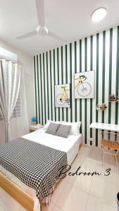 Grand Green Homestay في Sungai Pelik: غرفة نوم بسرير وشراشف خضراء وبيضاء