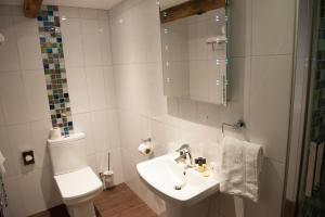 a white bathroom with a toilet and a sink at Hotel Forty One in Great Driffield