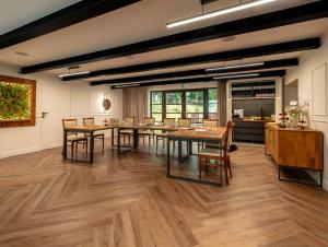 a dining room with wooden tables and a kitchen at Pałac w Małkowie in Warta