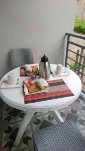 a white table with a plate of food on it at Haven Guest House in Kasese