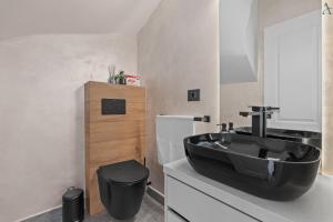 bagno con lavandino nero e servizi igienici di DaVinci Smart Villa a Otopeni Altre 33 foto