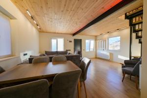 Una sala de estar con un sofá, una mesa y sillas. en Gudauri Private Cottage 2, en Gudauri