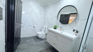 Newly Renovated Room,Bathroom and private Kitchen في Banjupp Station: حمام أبيض مع حوض ومرآة +13 صورة