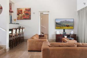 een woonkamer met twee banken en een tafel bij Dierama Dream Cathkin Estates in Ardmore