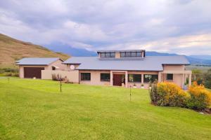 een huis op een heuvel met een groen gazon bij Dierama Dream Cathkin Estates in Ardmore