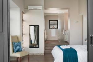 een slaapkamer met een bed en een spiegel en een badkamer bij Dierama Dream Cathkin Estates in Ardmore