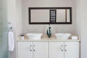 een badkamer met twee wastafels en een spiegel bij Dierama Dream Cathkin Estates in Ardmore +25 foto's