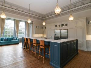 een keuken met een groot eiland met barkrukken bij Frenchay Park House in Bristol