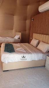 een slaapkamer met 2 bedden in een kamer met bij Nadine Luxury Camp in Wadi Rum
