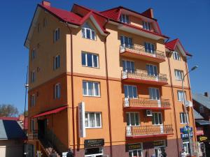 um edifício laranja alto com um telhado vermelho em Truskavets Elit Apartment em Truskavets