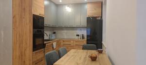 eine Küche mit einem Holztisch und einem schwarzen Kühlschrank in der Unterkunft Apartament u Jacka - 400m od Zamojskiej Starówki in Zamość + 16 Fotos