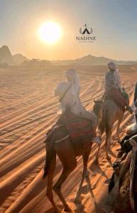 een groep mensen die paardrijden in de woestijn bij Nadine Luxury Camp in Wadi Rum