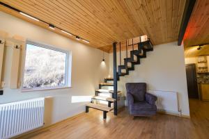 Una sala de estar con una escalera y una silla. en Gudauri Private Cottage 2, en Gudauri 15 fotos más