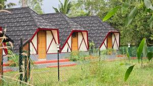 a small house with a black roof at Pattaya Village in Kollam +4 photos