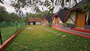 a house with a fence next to a yard at Pattaya Village in Kollam