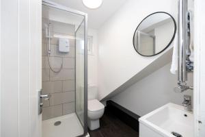 a bathroom with a shower and a toilet and a mirror at Stunning 3 Bedroom Home in Newcastle-under-Lyme with Garden in Newcastle under Lyme