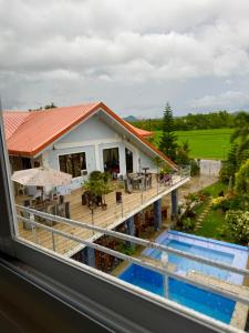 SaraTUBURAN Poolside的从带游泳池的房子的窗户欣赏美景