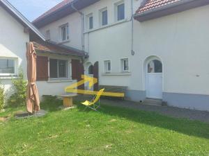 una panchina gialla nel cortile di una casa di Les Brimbelles a Brû