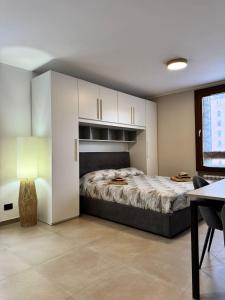 a bedroom with a large bed with white cabinets at Tonale Sweet House in Passo del Tonale
