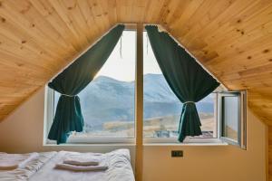 a bedroom with a large window with a mountain view at Gudauri Private Cottage 2 in Gudauri