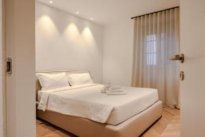a bedroom with a bed with white sheets and a window at Palazzo Machiavelli Trieste in Trieste +26 photos