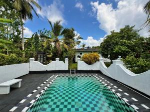 a swimming pool in the backyard of a house at Paddy View Villa in Pedinnoruwa