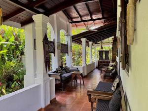 a porch of a house with chairs and tables at Paddy View Villa in Pedinnoruwa