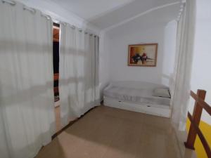 una stanza bianca con un letto e una finestra di O Casarão a Cotia