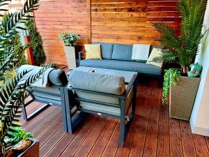 een patio met een blauwe bank op een houten terras bij Cisowa Garden Suite in Świdnik