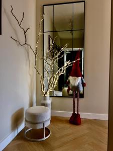 een kamer met een kerstmuts, een krukje en een spiegel bij Cisowa Garden Suite in Świdnik
