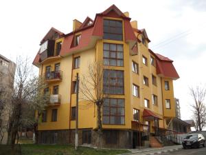 a yellow building with a red roof at Truskavets Lux Apartment in Truskavets