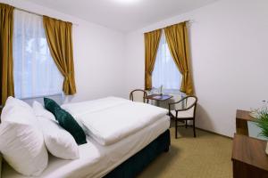 a hotel room with a bed and a table at Eagle Hotel in Šamorín