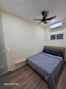 Un dormitorio con una cama y un ventilador de techo. en Bliss Homestay, en Simpang Ampat