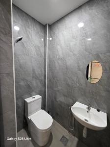 Un baño con un inodoro blanco y un lavabo. en Bliss Homestay, en Simpang Ampat
